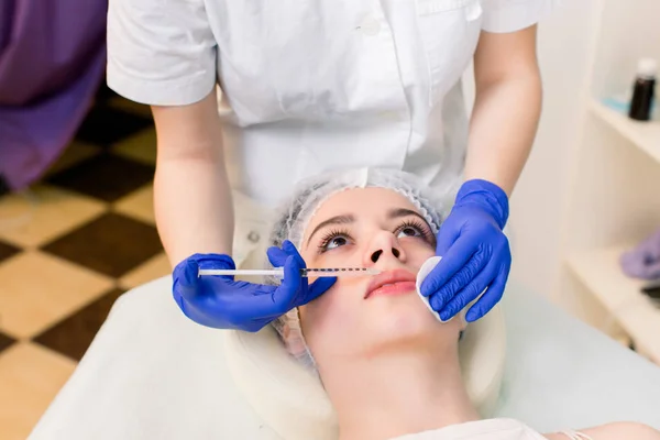 Lip Augmentation. Beautiful Young Woman\'s Mouth Receiving Hyaluronic Acid Injection. Closeup Of Beautician Hands Doing Beauty Procedure To Sexy Female Lips. Cosmetology Treatment. High Resolution