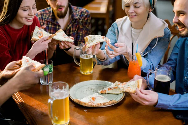 Çok ırklı mutlu gençler pizzacıpizza yemek, neşeli arkadaşlar restoran masada birlikte oturan eğlenerek yemek zevk gülüyor, çeşitli arkadaşlar toplantıda öğle yemeği paylaşmak — Stok fotoğraf