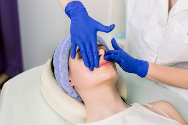 Genç güzel kız spa salonunda rahatlatıcı yüz masajı olan. Masaj masasında yatan spa salonunda kadın resmi