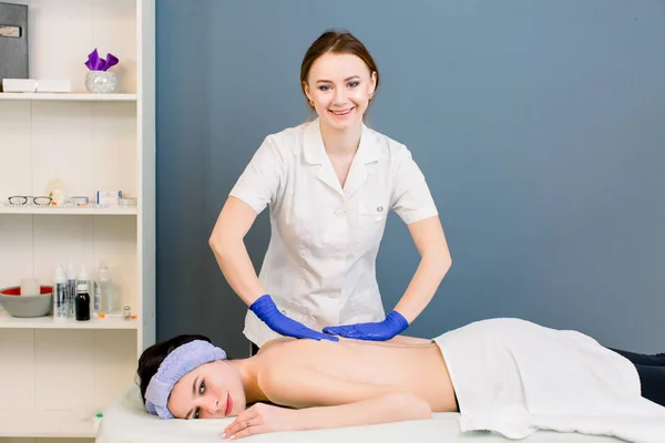 Back Massage Using Medical Steel Metal Massager Scraper. Lady