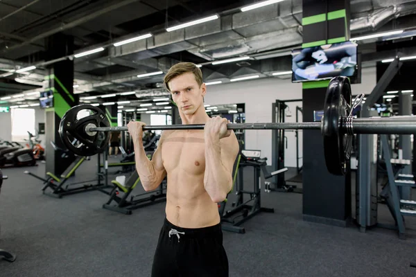 Крупный план тренировки мускулистого человека с штангой в тренажерном зале — стоковое фото