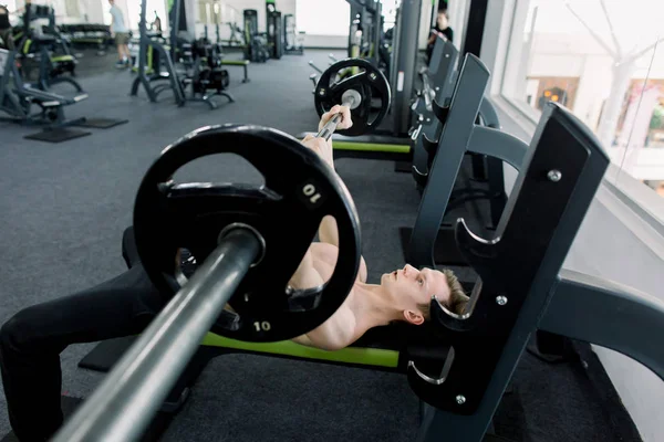 Man met barbell tijdens Bench Press oefening in de sportschool. Volwassen man in Gym oefenen op de Bench Press — Stockfoto