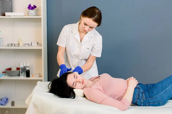 Bellezza dei capelli, mesoterapia: un estetista medico tricologo esamina la testa di una giovane bella donna nel centro estetico termale — Foto Stock