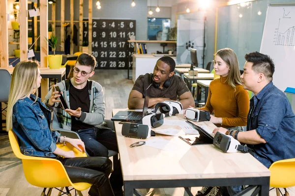 Teamwork försöker enheter och Virtual Reality glasögon för arbete i Creative Office. Fem olika unga människor som använder ny teknik vid uppstart. Trender, samhälls-och affärsidé — Stockfoto