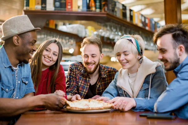 Yakın mutlu çeşitli arkadaşlar birlikte kafede pizza yemek, dilim ısırma, kafeterya da toplantıda İtalyan abur cubur zevk çok ırklı insanlar, birlikte eğlenmek, memnun müşteriler — Stok fotoğraf