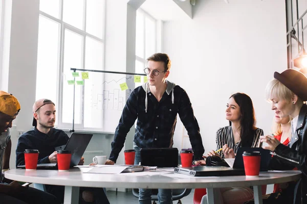 Le travail d'équipe et le travail d'équipe sont un succès. Partenaires de démarrage occupés travaillant dans des vêtements décontractés, à l'écoute du leader, discuter des idées pour une nouvelle stratégie de développement à un bureau léger agréable et confortable — Photo