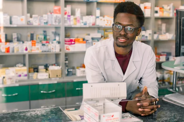 Zkušený Afričan americký farmaceutik v bílém plášti pracující v moderní lékárně — Stock fotografie