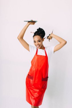 Güzel genç Afro-Amerikan güzellik kadını beyaz izole, fırçalar ve göz farları makyaj seti tutan