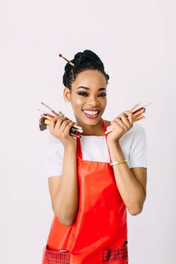 Güzel genç Afrikalı Amerikalı güzellik kadını makyaj fırçaları seti tutarak.