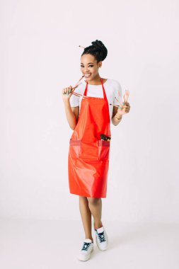 Güzel genç Afrikalı Amerikalı güzellik kadını makyaj fırçaları seti tutarak.