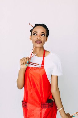 Güzel genç Afrikalı Amerikalı güzellik kadını makyaj fırçaları seti tutarak.