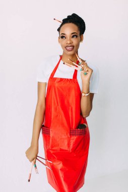 Güzel genç Afrikalı Amerikalı güzellik kadını makyaj fırçaları seti tutarak.