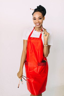 Güzel genç Afrikalı Amerikalı güzellik kadını makyaj fırçaları seti tutarak.