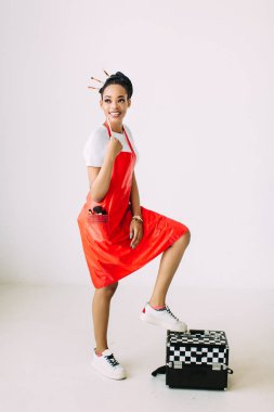 Güzel genç Afro-Amerikan güzellik kadın özel durumda makyaj ekipmanları seti tutan, beyaz arka plan üzerinde izole