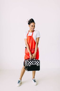 Güzel genç Afro-Amerikan güzellik kadın özel durumda makyaj ekipmanları seti tutan, beyaz arka plan üzerinde izole