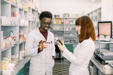 Eczanede çalışan iki eczacı adam ve kadın. Hastane eczanede ilaç kalitesini kontrol eden erkek ve kadın Eczacılar.