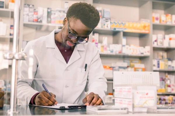 현대 약국에서 직장에서 처방전을 쓰는 행복한 아프리카 계 미국인 약사의 초상화 — 스톡 사진