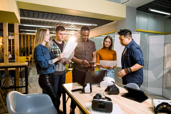 Unga människor programvara programmerare testa en ny Apps med 3D Virtual Reality Glasögon, bärbara datorer och tabletter i Office. — Stockfoto