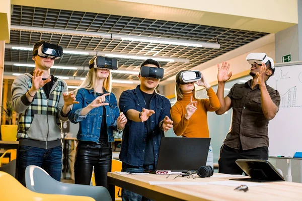 Incroyable cinq jeunes travailleurs indépendants collègues toucher l'air au cours de l'expérience VR. Plan horizontal . — Photo