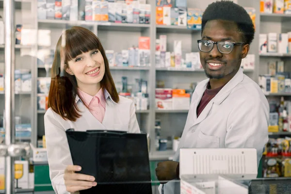 Portrait de deux pharmaciens multiethniques souriants travaillant dans une ferme moderne — Photo