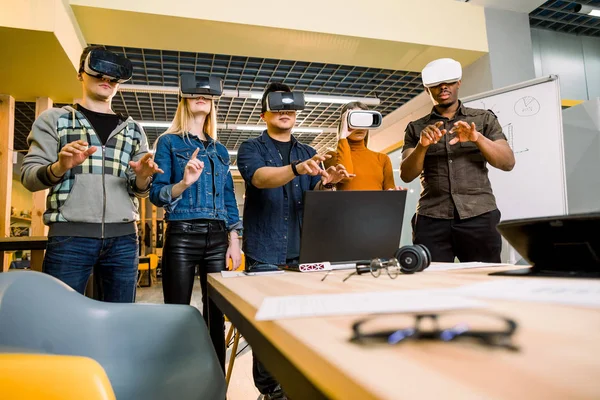 Team av utvecklare som arbetar med virtual reality-glasögon under ett affärsmöte. Unga affärskollegor brainstorming med Vr-glasögon. — Stockfoto
