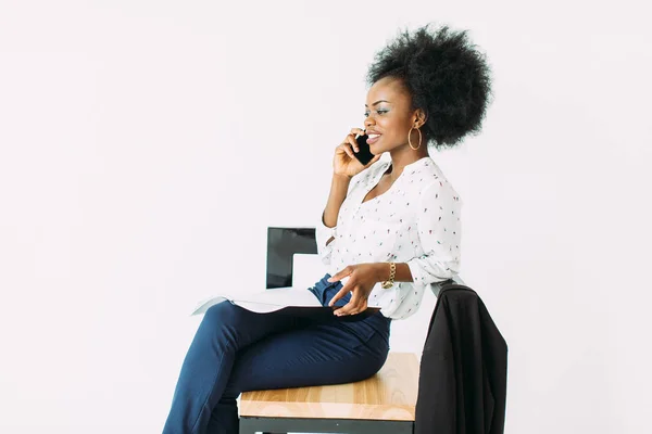 Giovane donna d'affari afroamericana che parla al telefono seduta sulla sedia — Foto Stock