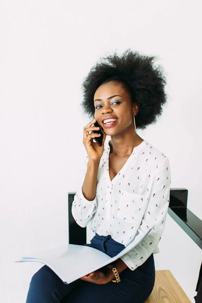 Giovane donna d'affari afro-americana sorridente usando il telefono, isolata su bianco — Foto Stock