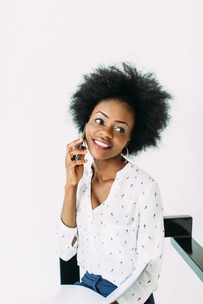 Giovane donna d'affari afro-americana sorridente usando il telefono, isolata su bianco — Foto Stock