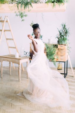 Stüdyoda tropikal buket ile güzel afrikalı amerikalı gelin