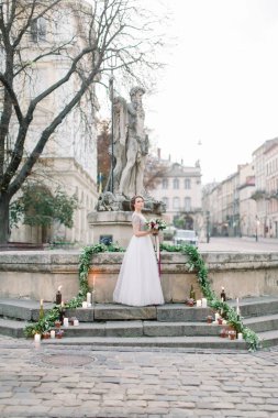 Eski şehirde çok güzel ve romantik açık düğün töreni. Canlı çiçekler, mumlar, merdivenler. Anıtın taş merdivenlerinde duran gelin