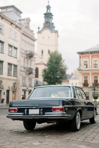 Черный классический ретро-автомобиль припарковался на старой европейской городской улице. Винтажный старый черный автомобиль перед центром Львова . — стоковое фото