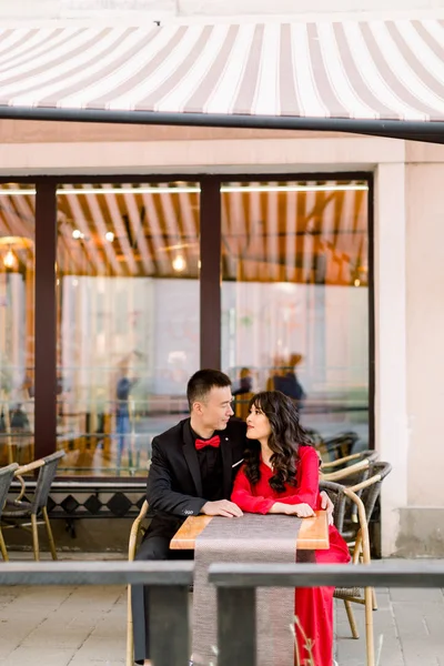 Estilo de vida al aire libre retrato de la joven pareja china enamorada en el casco antiguo en la calle, pareja sentada en la cafetería o restaurante, ciudad, Europa —  Fotos de Stock