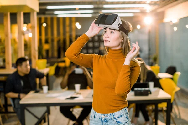 직장에서 3D VR 안경을 시도 오렌지 스웨터에 예쁜 여성 비즈니스 여성. 창의적인 사무실에서 함께 일하는 젊은이들의 다인종 팀 — 스톡 사진