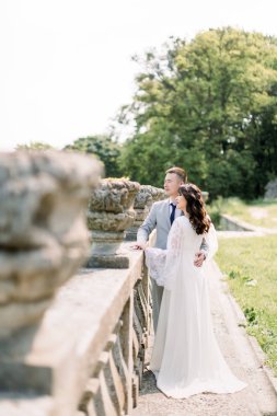Stylish bride and groom. wedding couple. Happy bride and groom on their wedding day. Groom and Bride walking near old castle. wedding dress.