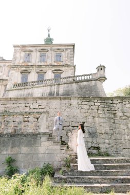 beautiful Asian couple in luxury clothes outdoors near the castle