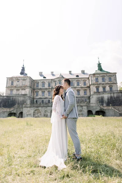 День весілля. Наречений і наречена, китайська пара, прогулянки біля старого замку, тримаючись за руки і обійматися — стокове фото