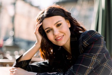 Siyah şık ceket inanılmaz genç esmer bayan yaz güneşportresi kadar yakın, gülümseyerek ve şehirde sabah açık havada zevk, yaz renkleri