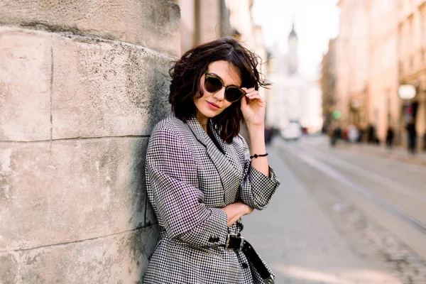 Moda attraente donna moderna in occhiali da sole in piedi sulla strada della città. Ritratto estivo di ragazza felice su una passeggiata — Foto Stock