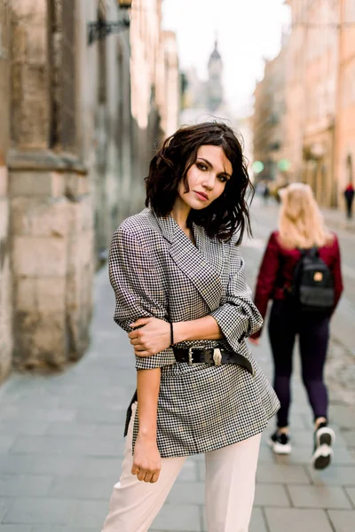 Menina bonita nova em roupas da moda andar na rua do centro da cidade velha, tempo do dia ensolarado, edifícios antigos no fundo — Fotografia de Stock