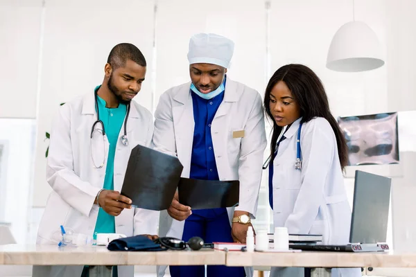 Team di giovani medici africani che discutono immagini radiologiche di pazienti in clinica. Moderno centro diagnostico. Medicina e concetto di assistenza sanitaria . — Foto Stock