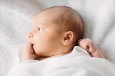 Beyaz saç bandı takmış, kürklü kumaş üzerinde uyuyan yeni doğmuş tatlı bir kız.