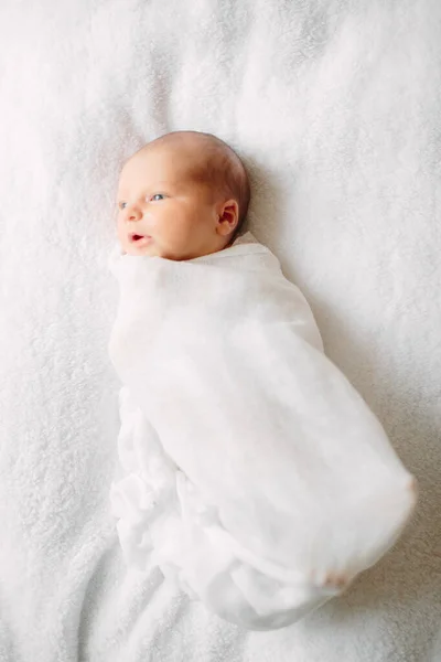 Söt nyfödd flicka sover på lurvig duk bär vitt pannband — Stockfoto