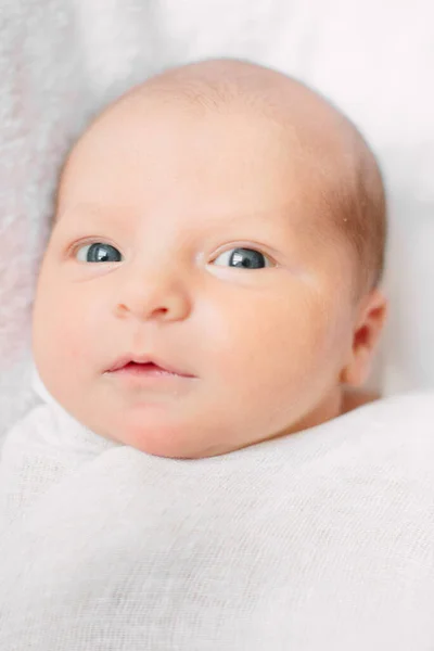 Beyaz saç bandı takmış, kürklü kumaşın üzerinde yatan tatlı yeni doğmuş kız. — Stok fotoğraf