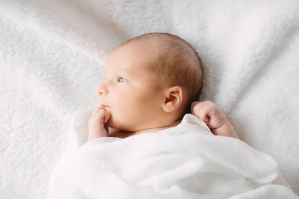Beyaz saç bandı takmış, kürklü kumaş üzerinde uyuyan yeni doğmuş tatlı bir kız. — Stok fotoğraf