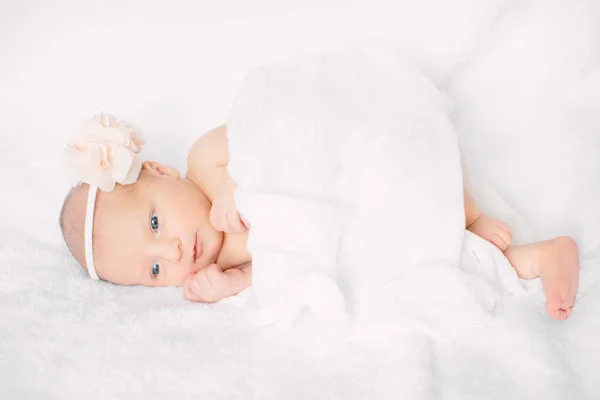 Aranyos újszülött lány alszik szőrös ruha visel fehér fejpánt — Stock Fotó