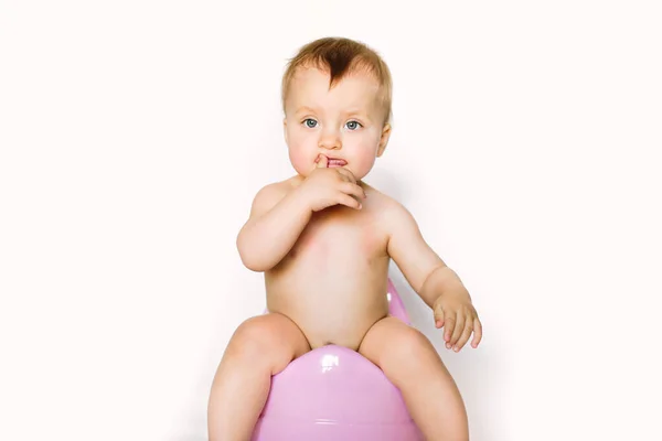 Маленькая девочка малыша ребенок сидит на пластиковом горшке на белом фоне — стоковое фото