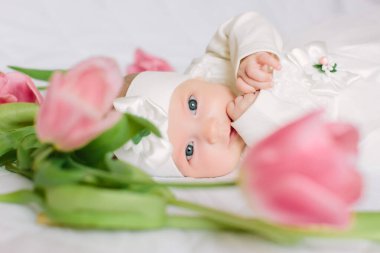 Küçük güzel yeni doğmuş kız çiçeklerin arasında yatıyordu.