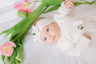 Küçük güzel yeni doğmuş kız çiçeklerin arasında yatıyordu.