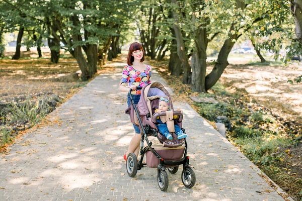 Οικογένειας, της μητρότητας και άνθρωποι έννοια - ευτυχισμένη μητέρα με το παιδί στο καροτσάκι στο πάρκο καλοκαίρι — Φωτογραφία Αρχείου