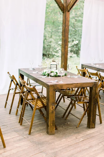 Banquete de casamento mesa de madeira em uma floresta ou jardim decorado com uma composição de flores brancas e vegetação, lanterna — Fotografia de Stock